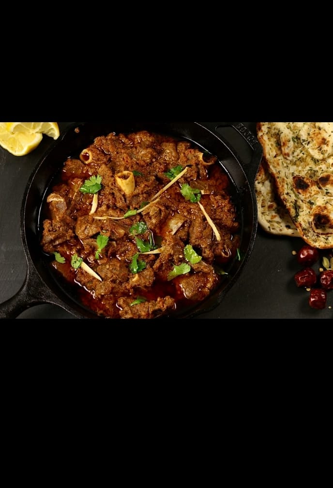 Shanwari Chicken Karahi served in a traditional karahi with fresh green chilies and coriander – ZaikaMenu