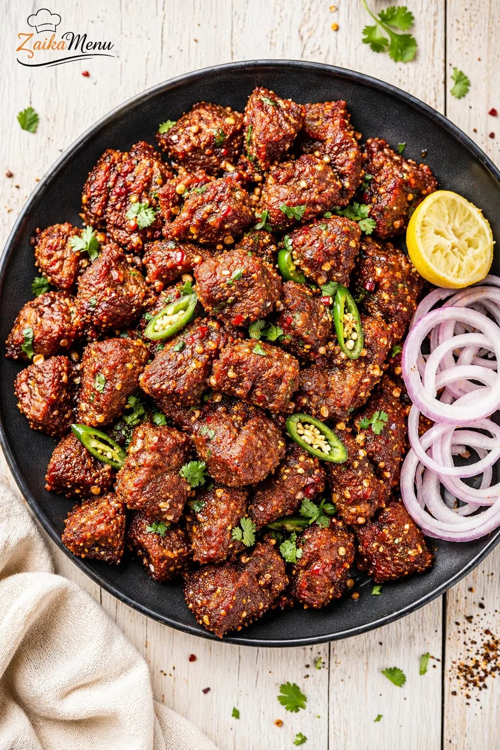 Step by step Beef Chatkhara Boti serving plate with onion rings and lemon - ZaikaMenu